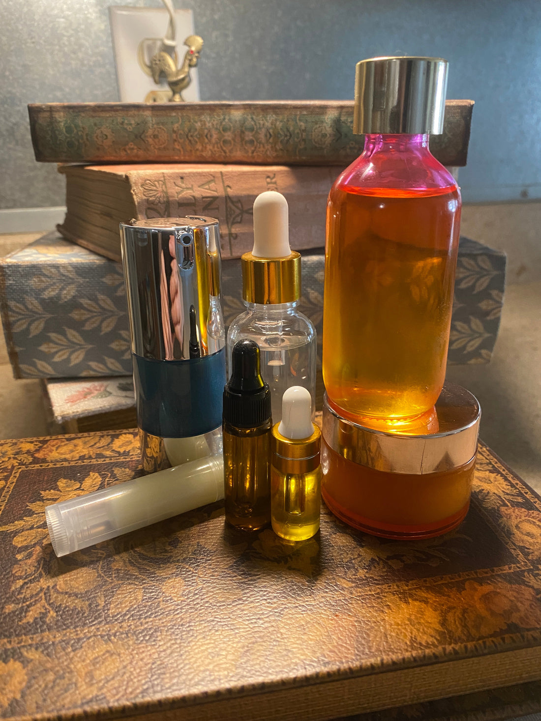 Seven Seas & Seven Stars™ skincare lineup with a blue airless pump, clear and amber dropper bottles, lip tube, and golden balm jar