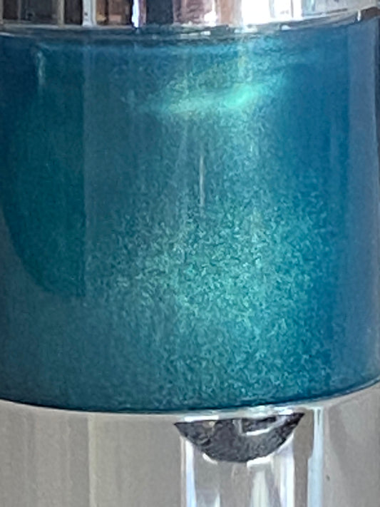 Close-up of the shimmering blue formula inside the Blue Galactic Sea Flower airless pump bottle